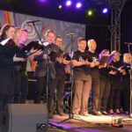 Zdjęcie przedstawia chórzystów na scenie